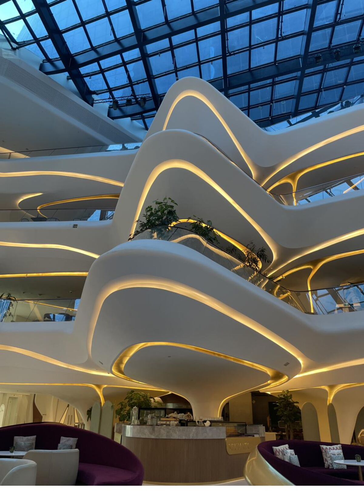 Sculptural, light-filled interior architecture with flowing tiered balconies.